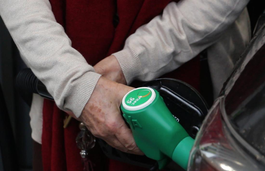 Un client se subministra carburant en una estació de servei.