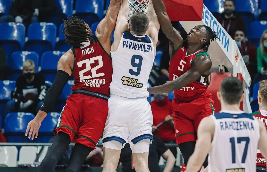 El pivot Artsiom Parakhouski realitza una esmaixada amb la samarreta del BC Tsmoki-Minsk davant de Lynch i Hervey (‘Loko’). Foto: Lokomotiv Kuban / VTB League