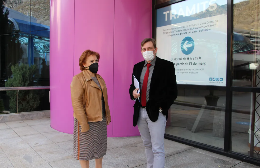 Josefina Rodríguez i Miquel Alís davant del cartell informatiu de la nova localització del Servei de Tràmits.