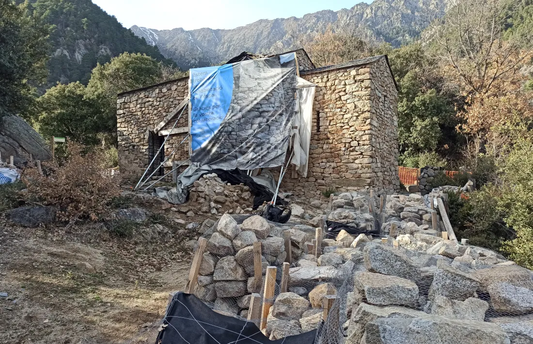 Aspecte actual de Sant Vicenç d’Enclar, amb el forat del campanar cobert per una lona, i les pedres apilades i ordenades.