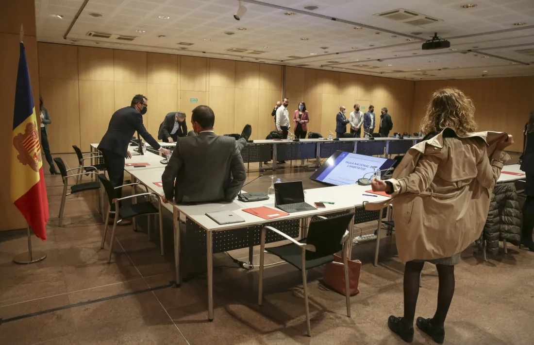 Instants previs a l’inici de la Taula Nacional de l’Habitatge amb el ministre d’Ordenament Territorial, Jordi Torres, saltant per damunt la taula per endollar uns cables, aquest dilluns.