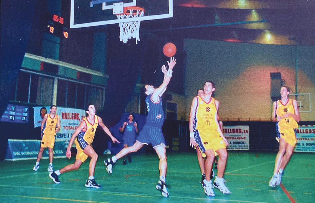 Hèctor Grau realitza una entrada a cistella davant de l’atenta mirada de Juan Carlos Navarro, a l’esquerra, i Pau Gasol, a la dreta. Foto: Màrius Grau