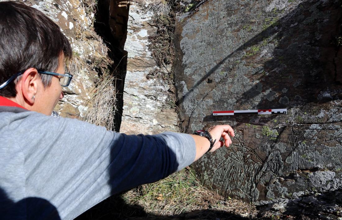 L'arqueòleg assenyala un dels gravats del conjunt.