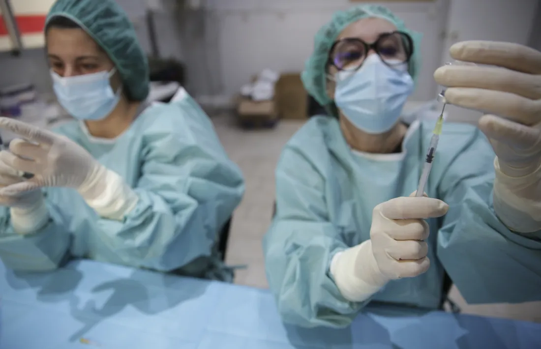 Personal de farmàcia preparant les dosis de vaccí a la plaça de Braus.