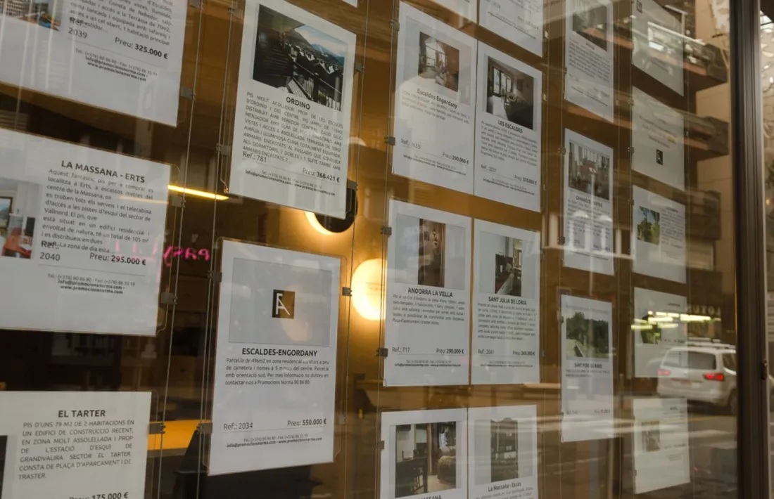 Anuncis de pisos penjats a l'aparador d'una immobiliària.