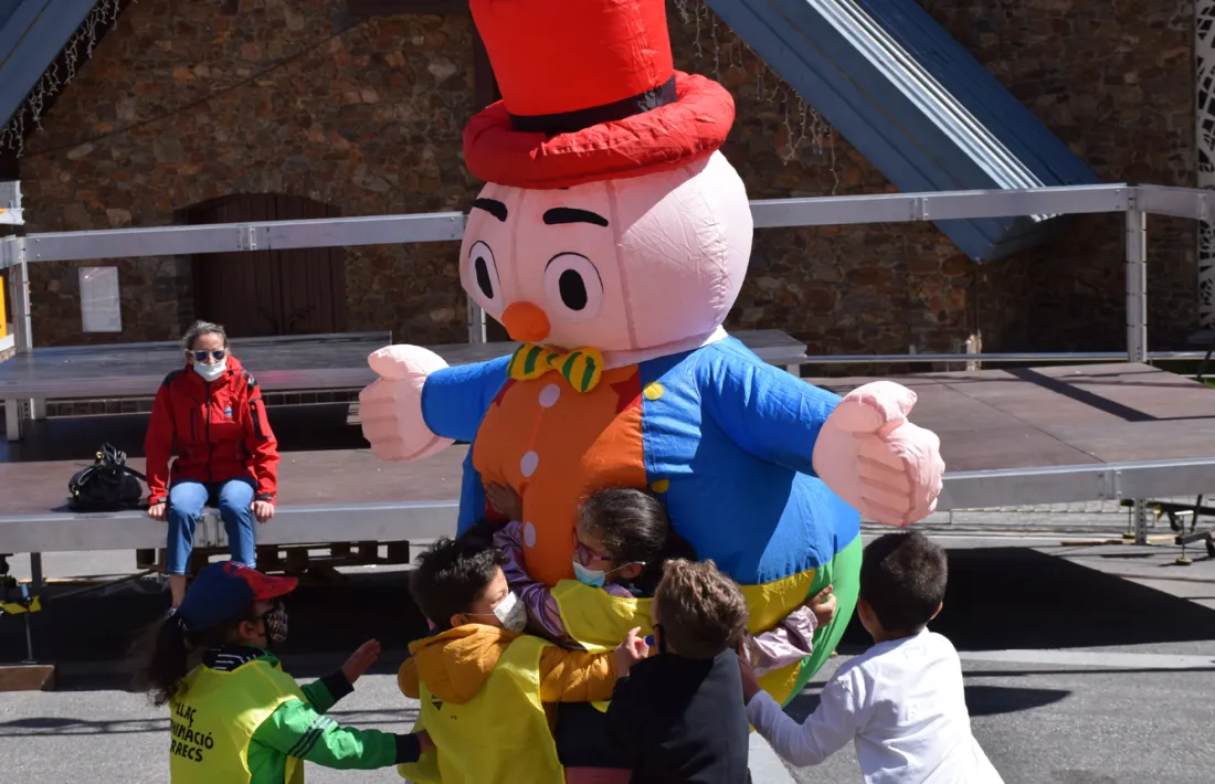 Infants abracen un dels personatges que ha participat en la desfilada.