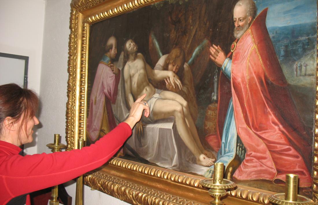 La restauradora Mireia Tarrés observa l’‘Enterrament’, oli barroc que es conserva a la sagristia de Sant Esteve.