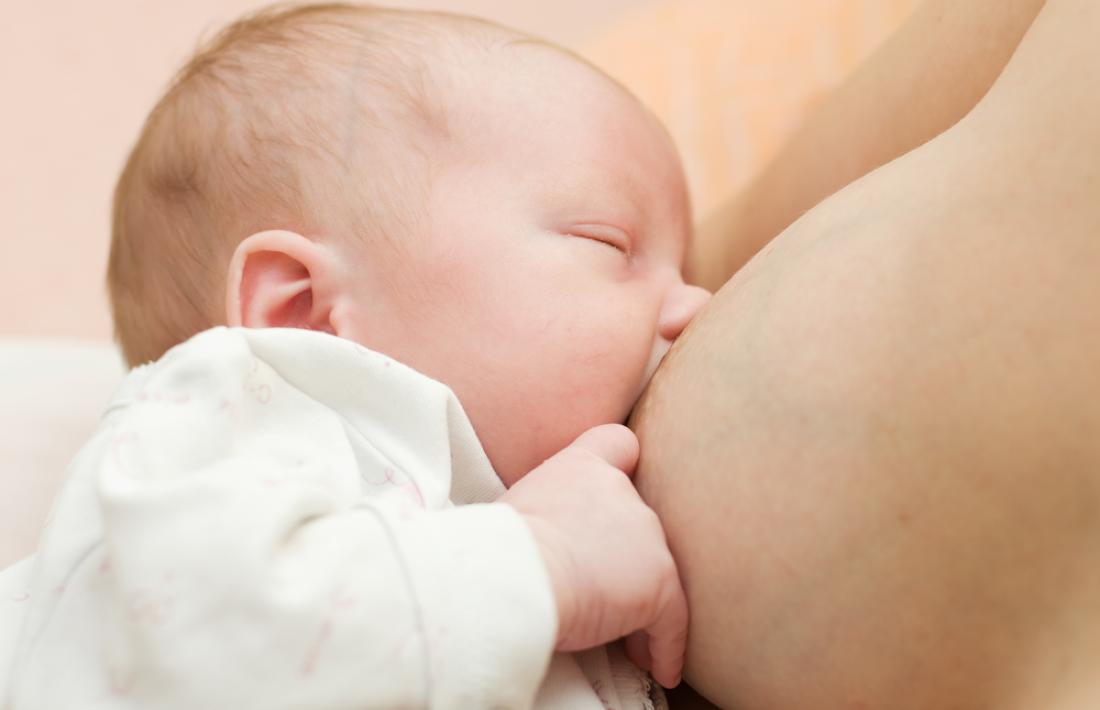 Un nadó mamant del pit de la seva mare.