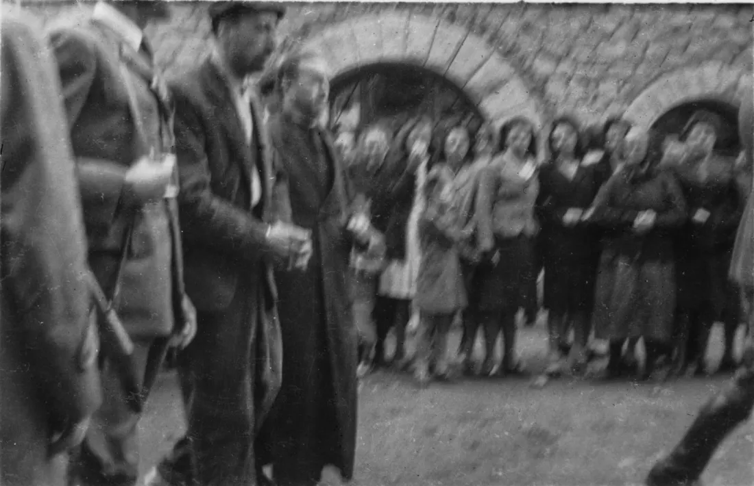 Plaça Benlloch, 18 d’octubre del 1943: Pere Areny, entre un policia i mossèn Lluís Pujol, desfila cap al patíbul.