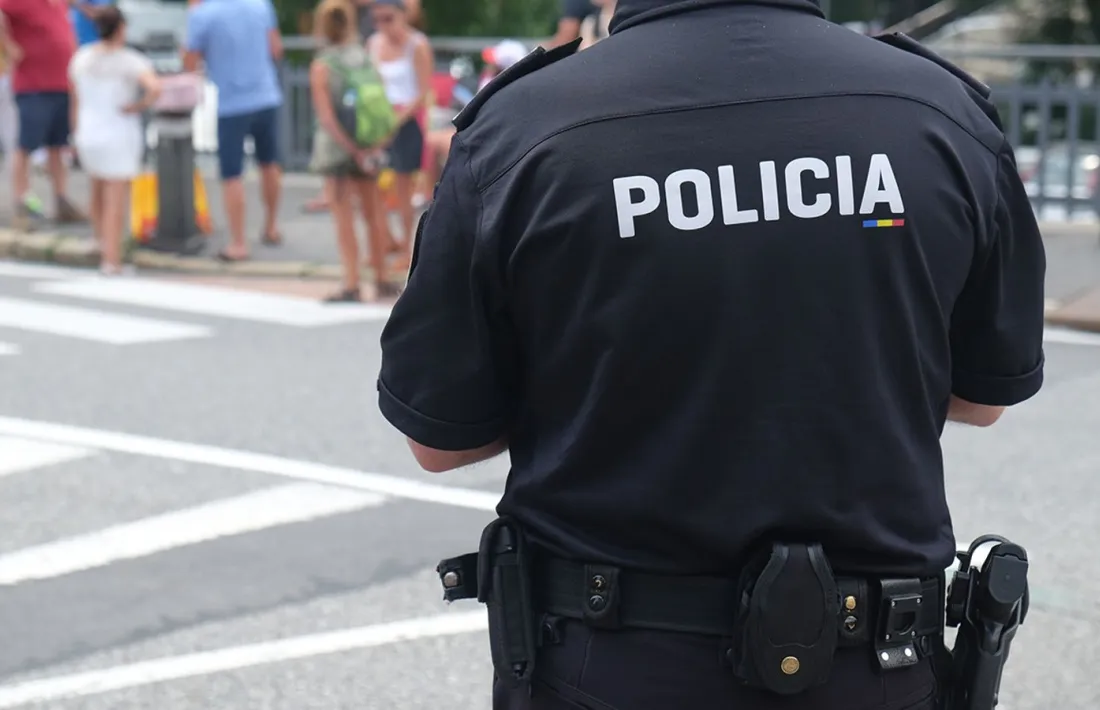 Un agent del cos de Policia d'esquenes.