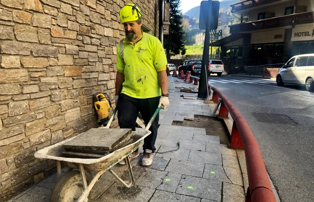 Un operari treballant en la reparació de les voreres.