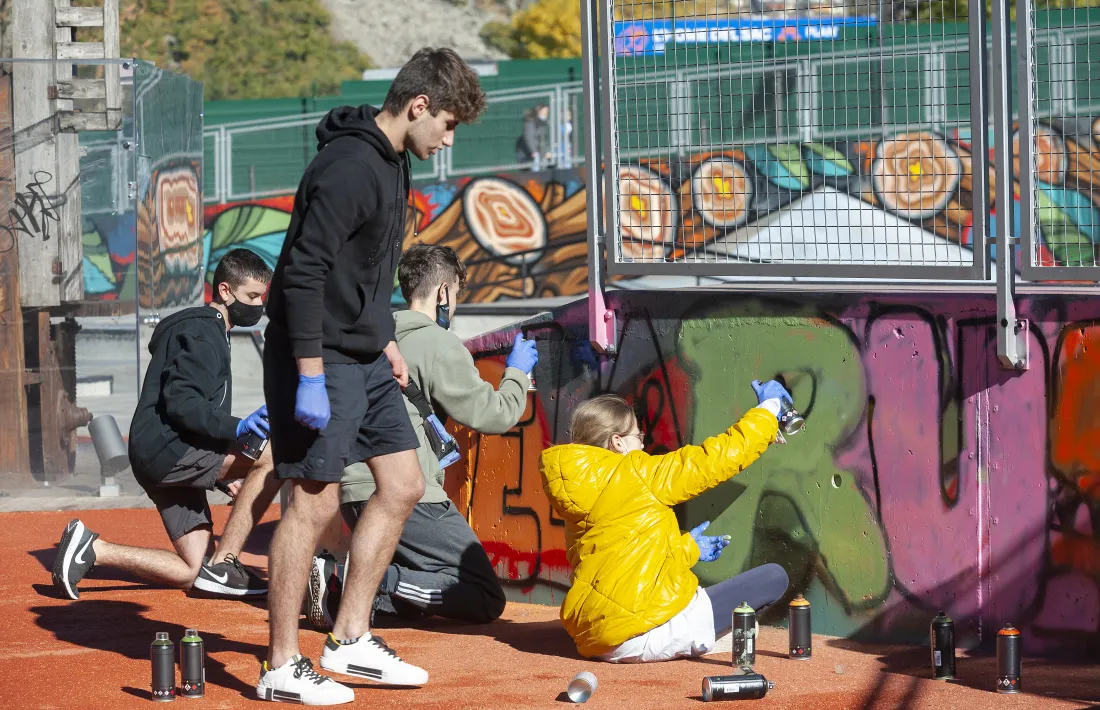 Infants col·laborant en la creació del mural de grafiti.