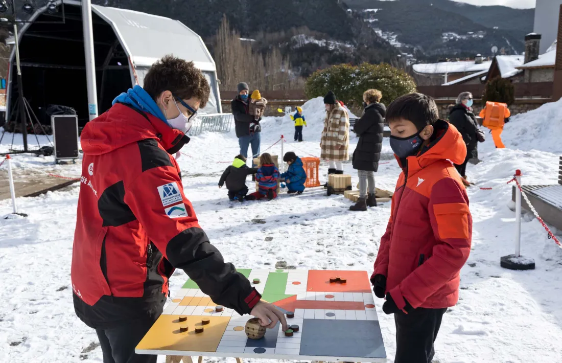 Uns nens juguen al parxís amb un tauler gegantí instal·lat en una plaça de Les Fontetes coberta de neu.