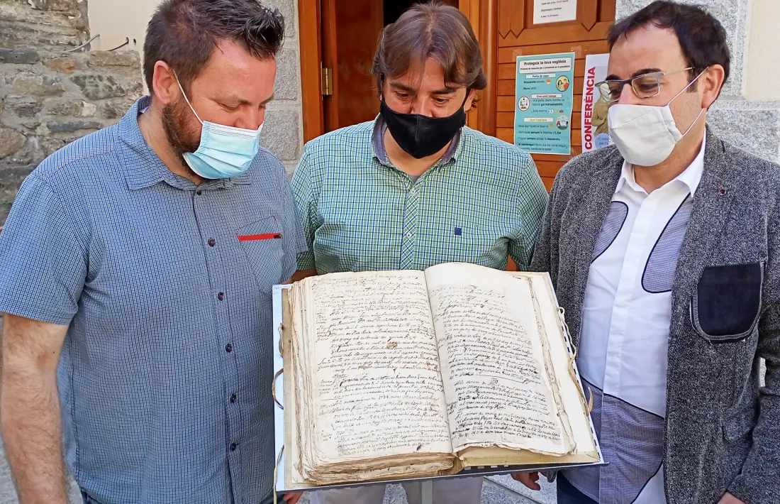 Lizarte, Valera i mossèn Pepe, amb el llibre d’òbits de Sant Julià, on consta la defunció de Simeón de Guinda el 27 d’agost del 1737.