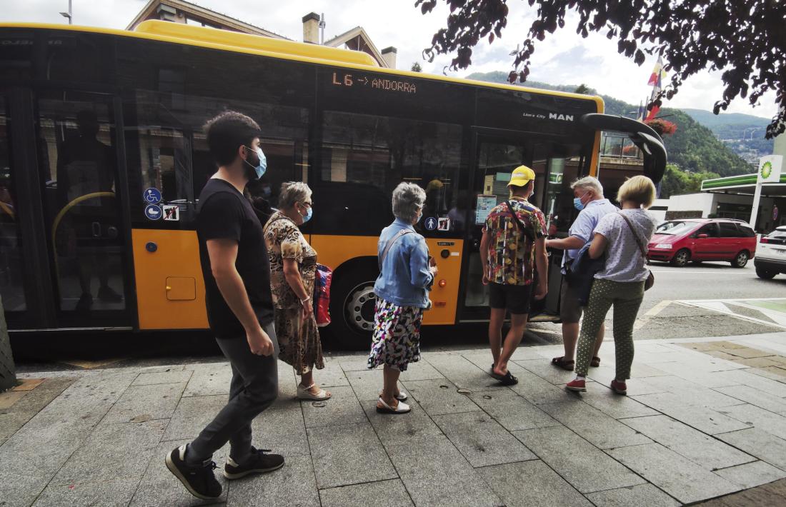 Usuaris del transport públic pujant a un autobús de l’L6 a la parada que hi ha al davant del Comú de la Massana.