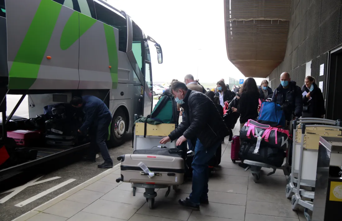 Els turistes suecs a la sortida de l'aeroport d'Alguaire amb l'autocar que els ha traslladat a Andorra.