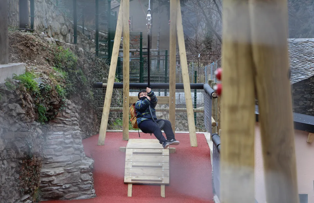 Un infant gaudint de la tirolina instal·lada al nou parc.