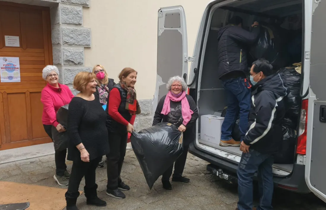 Voluntaris de Càritas descarregant una furgoneta amb material del Pas de la Casa.