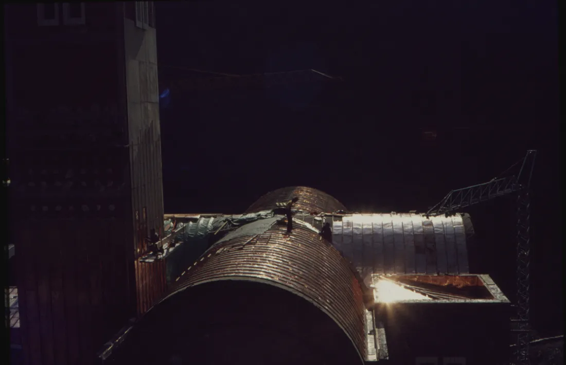 1975: dos operaris col·loquen els panells de coure a la teulada del santuari.