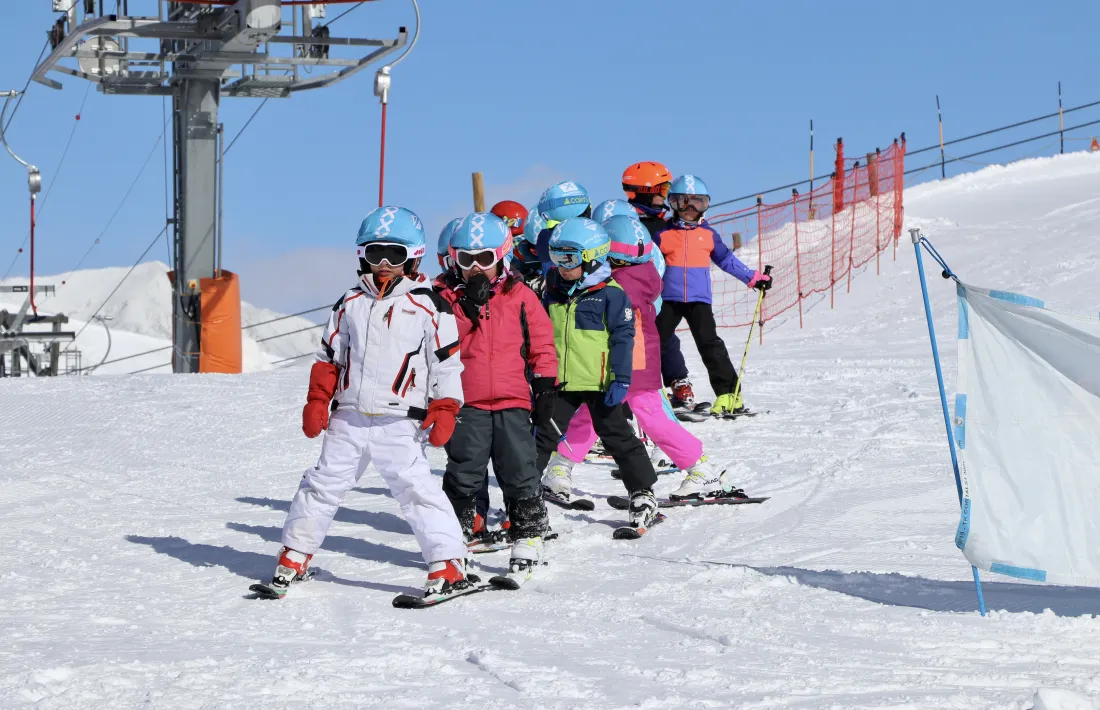 Un grup d'infants fent cua durant la darrera sessió de l'escola de neu d'Encamp.
