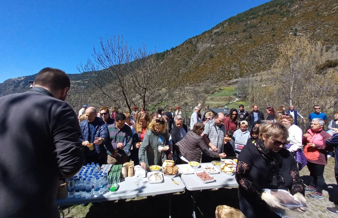 Un grup de persones agafa begudes i menjar de l'aperitiu.