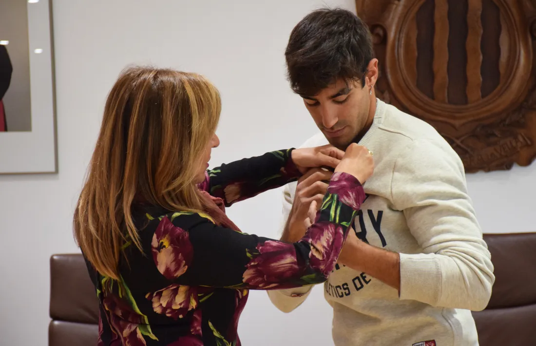 Conxita Marsol posant el pin de plata del Comú a l’esquiador Joan Verdú.