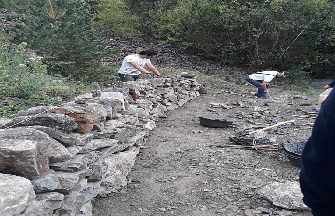 Imatge d'arxiu d'uns treballadors aplicant la tècnica de construcció de la pedra seca.