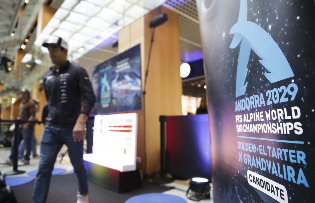 Joan Verdú, esquiador alpí de la FAE i vigent campió d’Europa de gegant, es passeja al costat del nou cartell, és a dir, el de la candidatura del Mundial 2029.