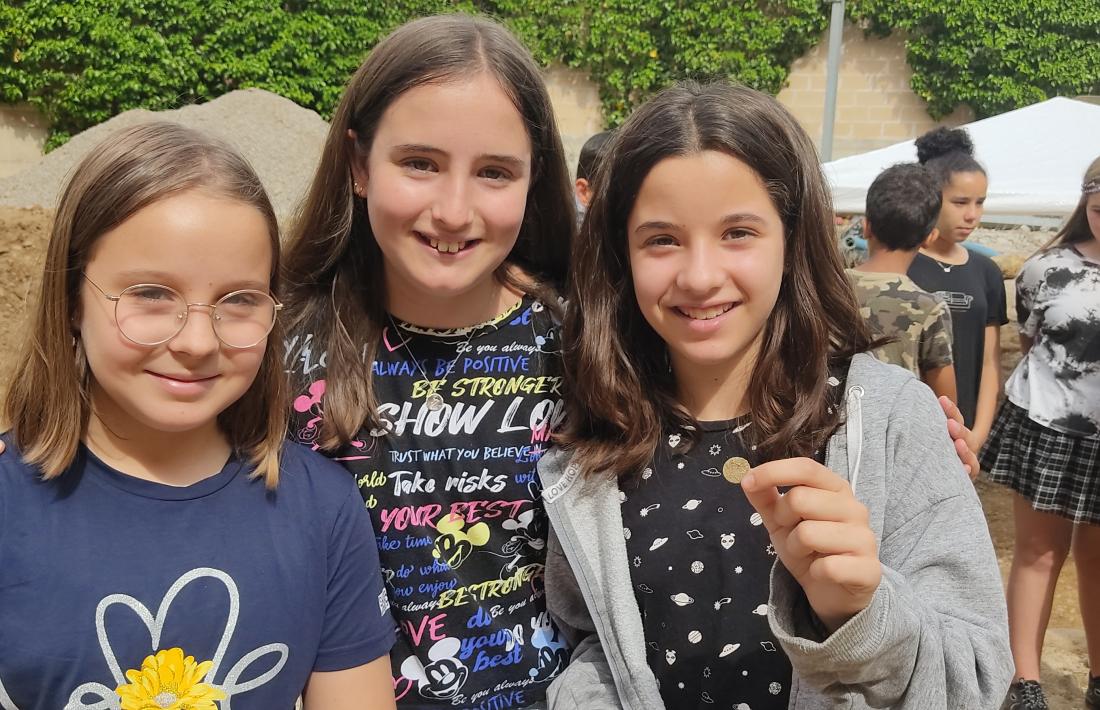 L’Èlia Manzanera, amb la seva troballa, i companyes de l’escola Pau Claris, durant la visita al jaciment.