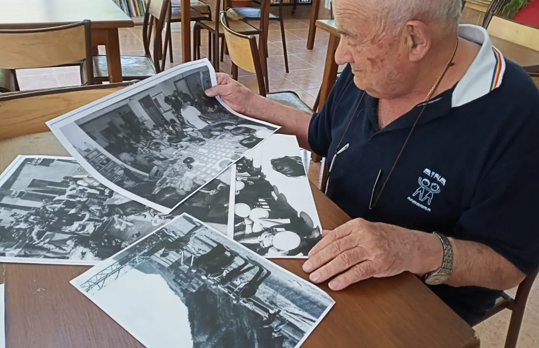 Mossèn observa documents de l'arxiu fotogràfic d'AINA, ahir a la casa de colònies.