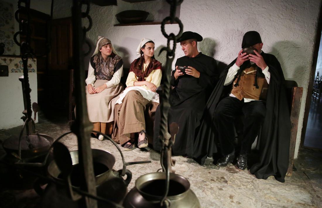 Mossèn Cinto  i el síndic Duran degusten un berenar reconstituent a la cuina de la Casa de la Vall.