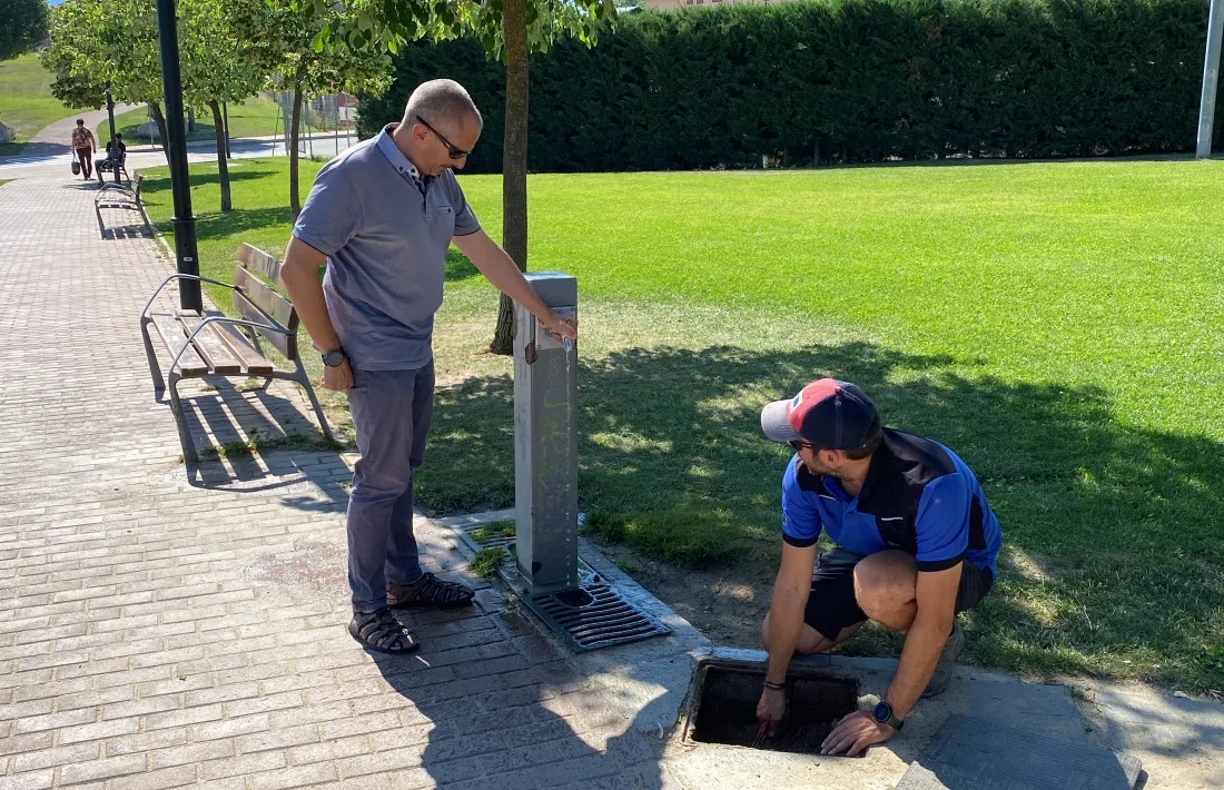 Operaris municipals comprovant el volum d’aigua que raja d’una font pública de Bellver de Cerdanya.