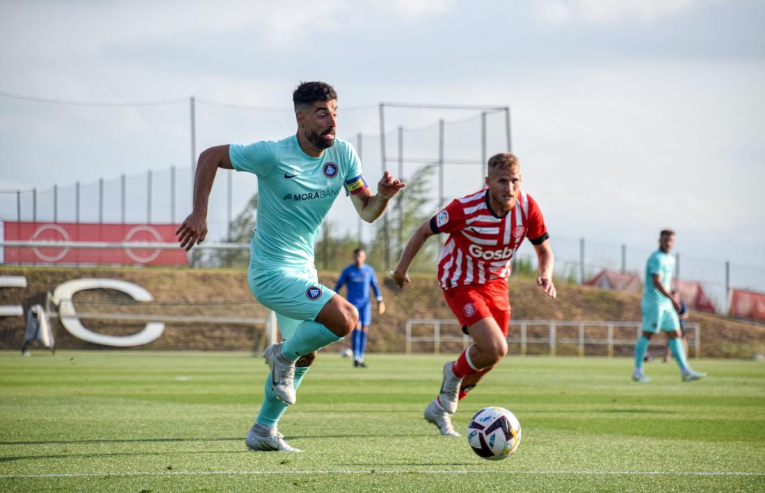 Carlos Martínez perseguit per Samu Saiz en l’amistós d’ahir a les instal·lacions de la ciutat esportiva del Girona.