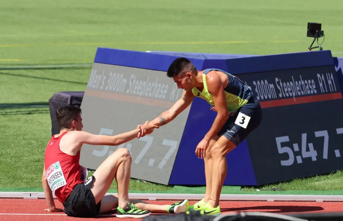 Nahuel Carabaña ajuda a aixecar-se a l'atleta danès, Axel Vang Christensen.