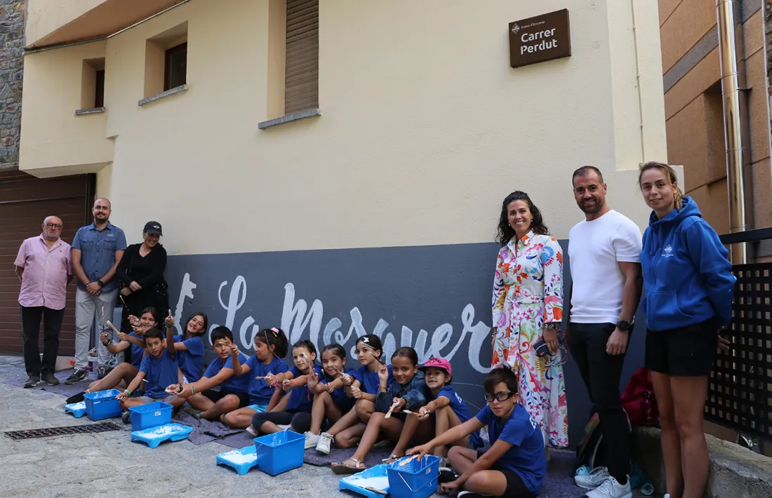 Els infants que han pintat el mural amb la cònsol i els consellers.