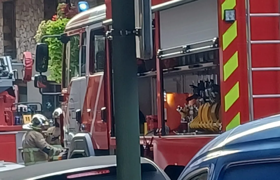 Dos vehicles del cos de bombers intervenint a l'edifici on surt fum.