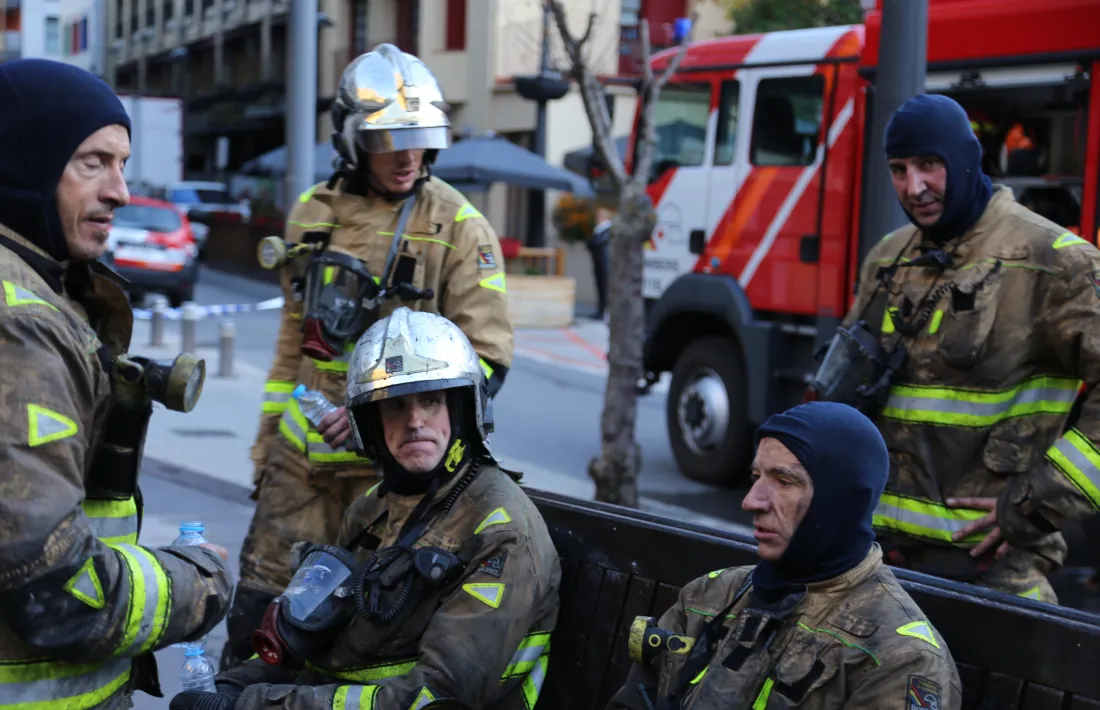 Membres del cos de bombers, visiblament cansats, després dels treballs d’extinció de l’incendi.