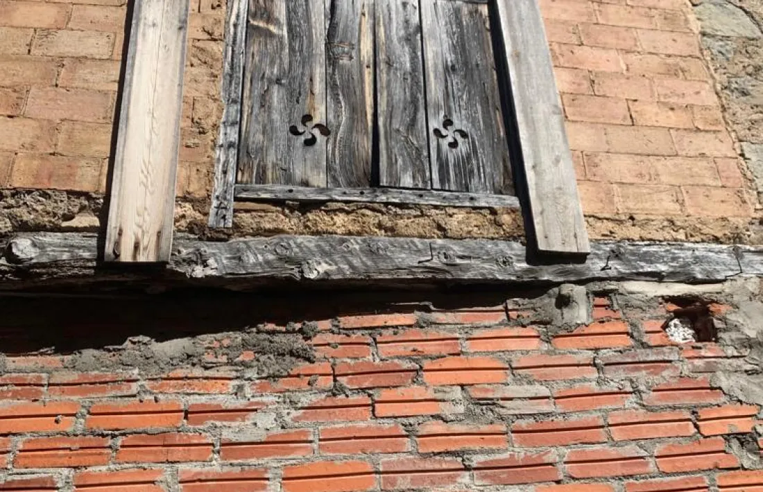 Respirall en forma de creu gammada en una finestra reaprofitada a Organyà.