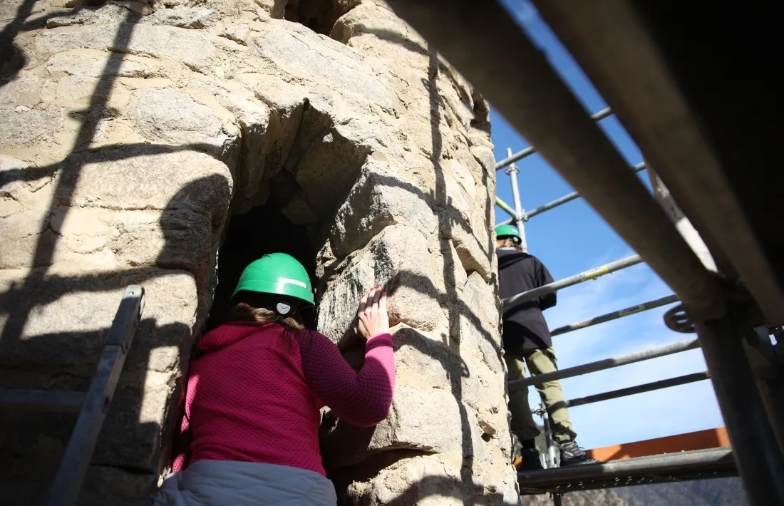 La ministra Riva, enfiada a la bastida, inspecciona un dels finestrals del campanar.