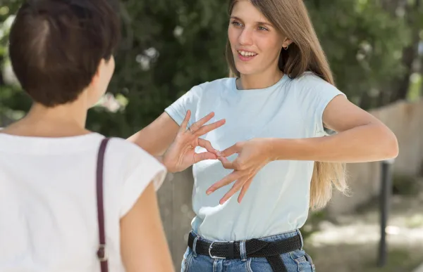 woman-conversing-with-friend-by-using-sign-language