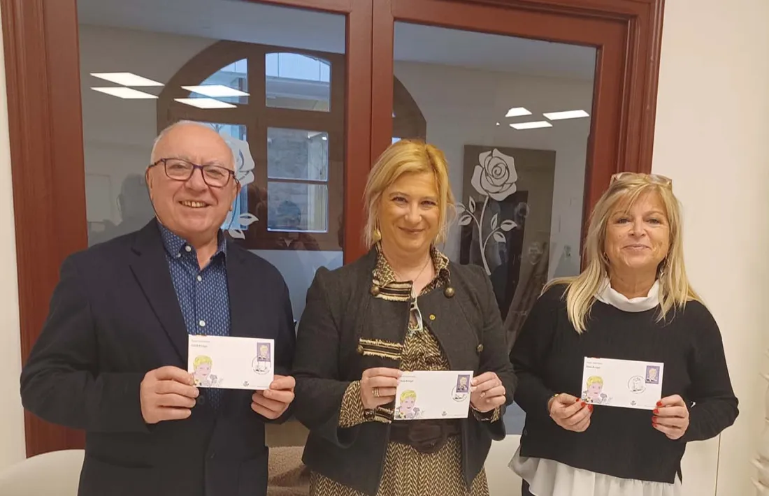 Enric Riba, Leire Diez i la directora de Promoció Cultural i Política Lingüística, Montserrat Planelles, amb el segell.