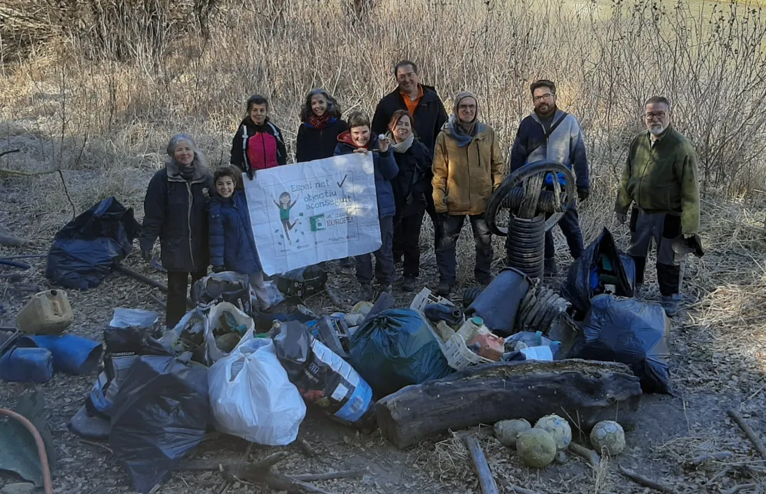 Els voluntaris, amb el fruit de l’acció realitzada aquest cap de setmana a les vores del pantà.