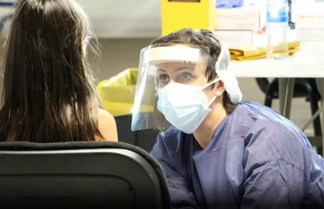 Una sanitària fa una prova de coronavirus a una nena.