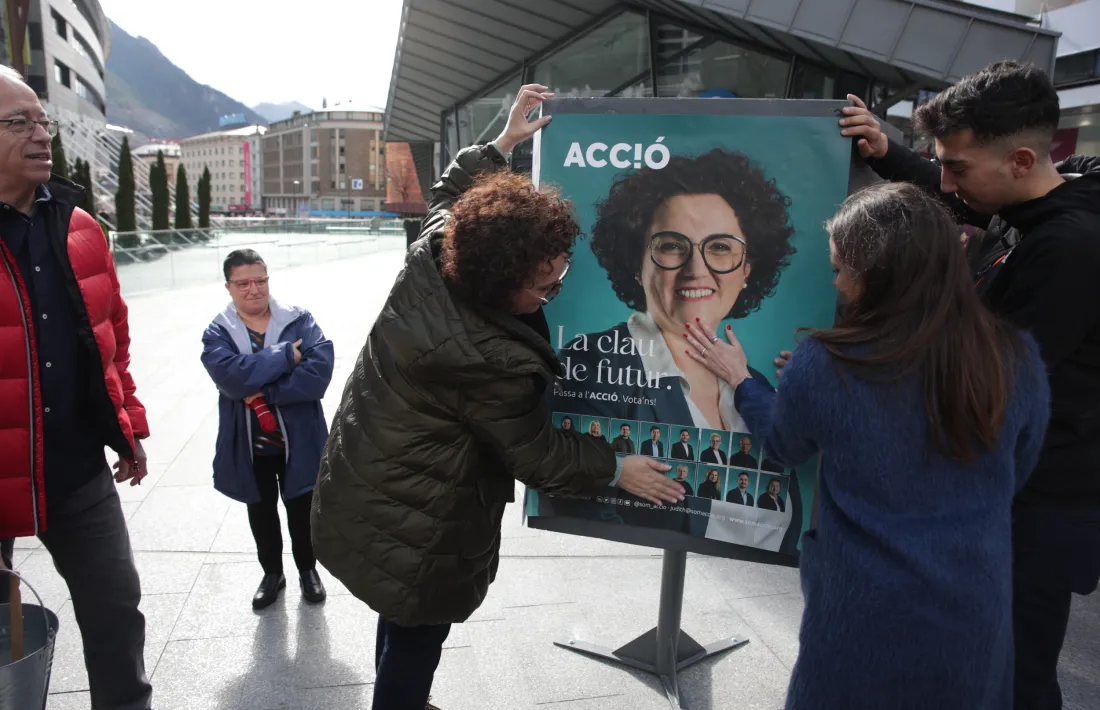 Un moment de l’enganxada de cartells d’Acció, avui a la plaça de la Rotonda.