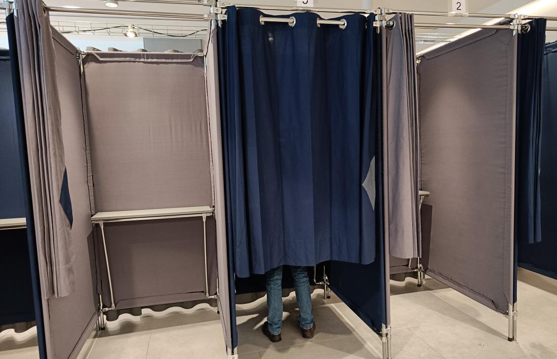 Una persona preparant el seu vot a les cabines instal·lades a la Batllia.