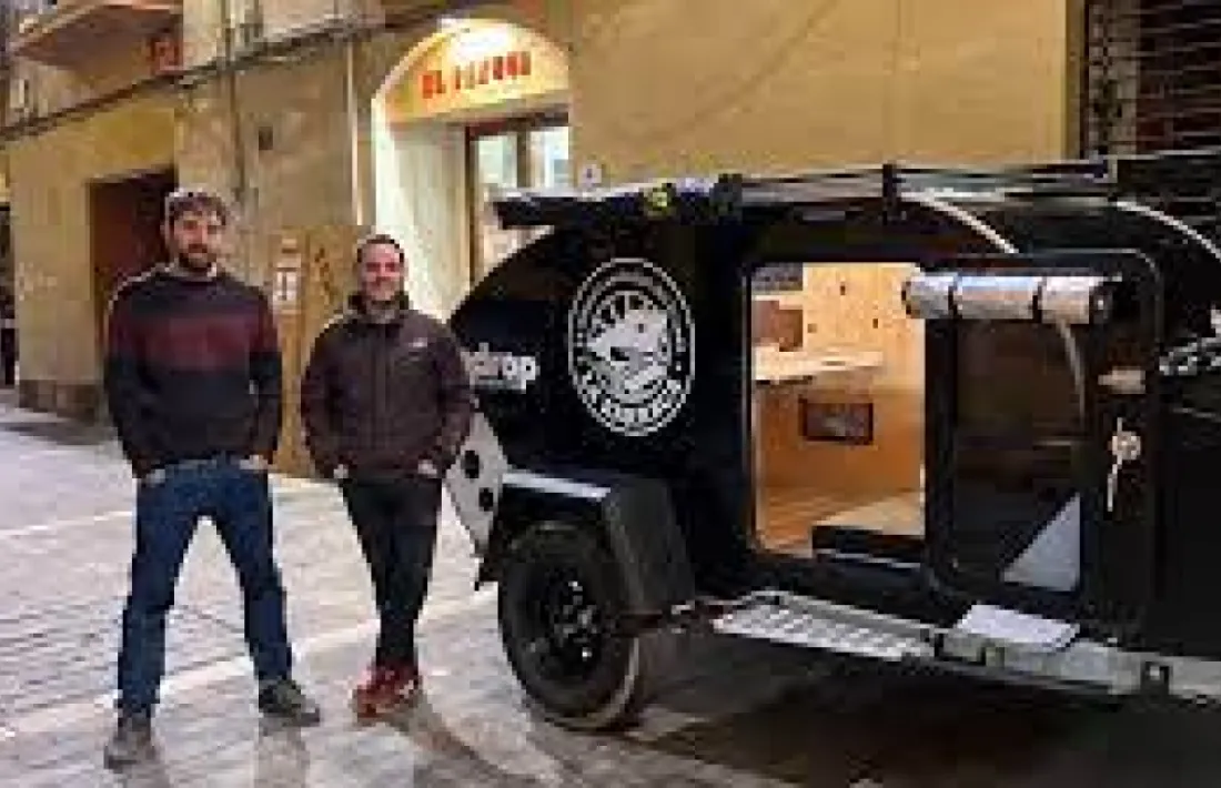 Pol Maese i Miquel Albero, amb el vehicle cultural, a la porta de la llibreria. 