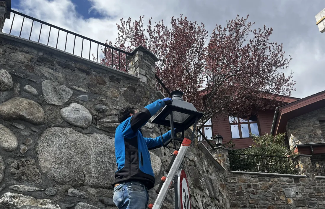 Un operari canviant el llum d'un fanal a la Massana.