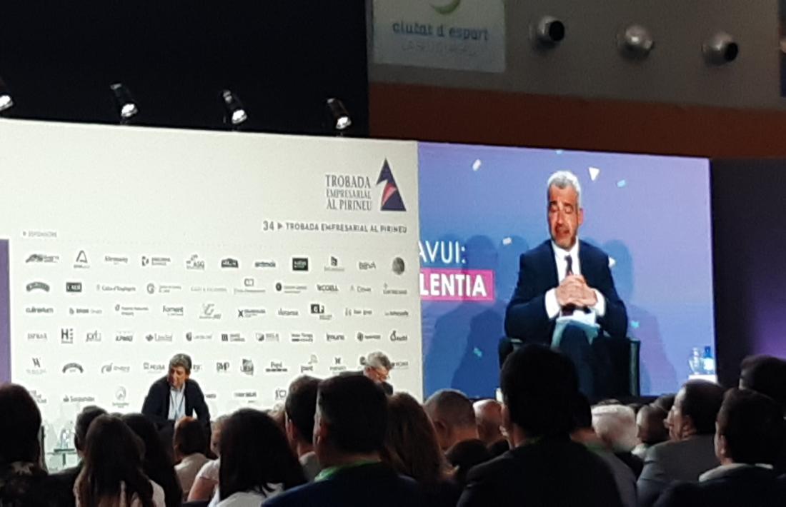 La primera taula de debat, amb Eloi Planes, conseller executiu de Fluidra, i Maurici Lucena, president d'AENA (en la pantalla). 