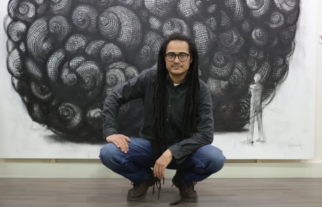 L’artista posa davant de l’estudi per a ‘Infinit i atzarós’, amb les closques de cargols construïdes amb daus i reminiscències fractals.