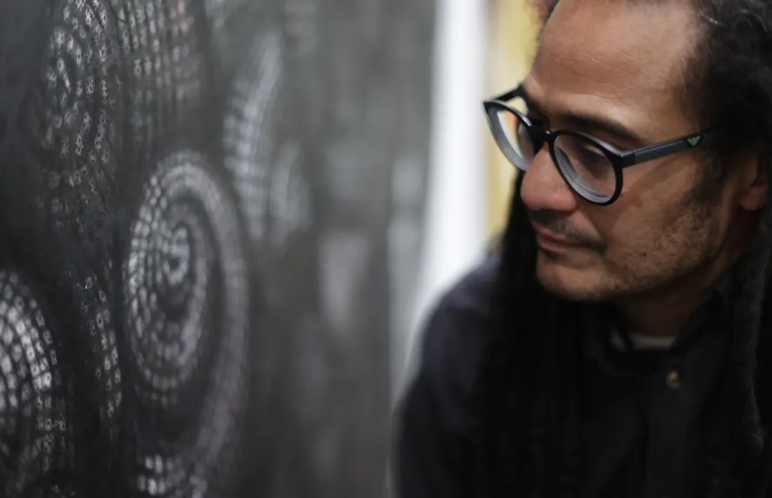 L’artista posa davant de l’estudi per a ‘Infinit i atzarós’, amb les closques de cargols construïdes amb daus i reminiscències fractals.